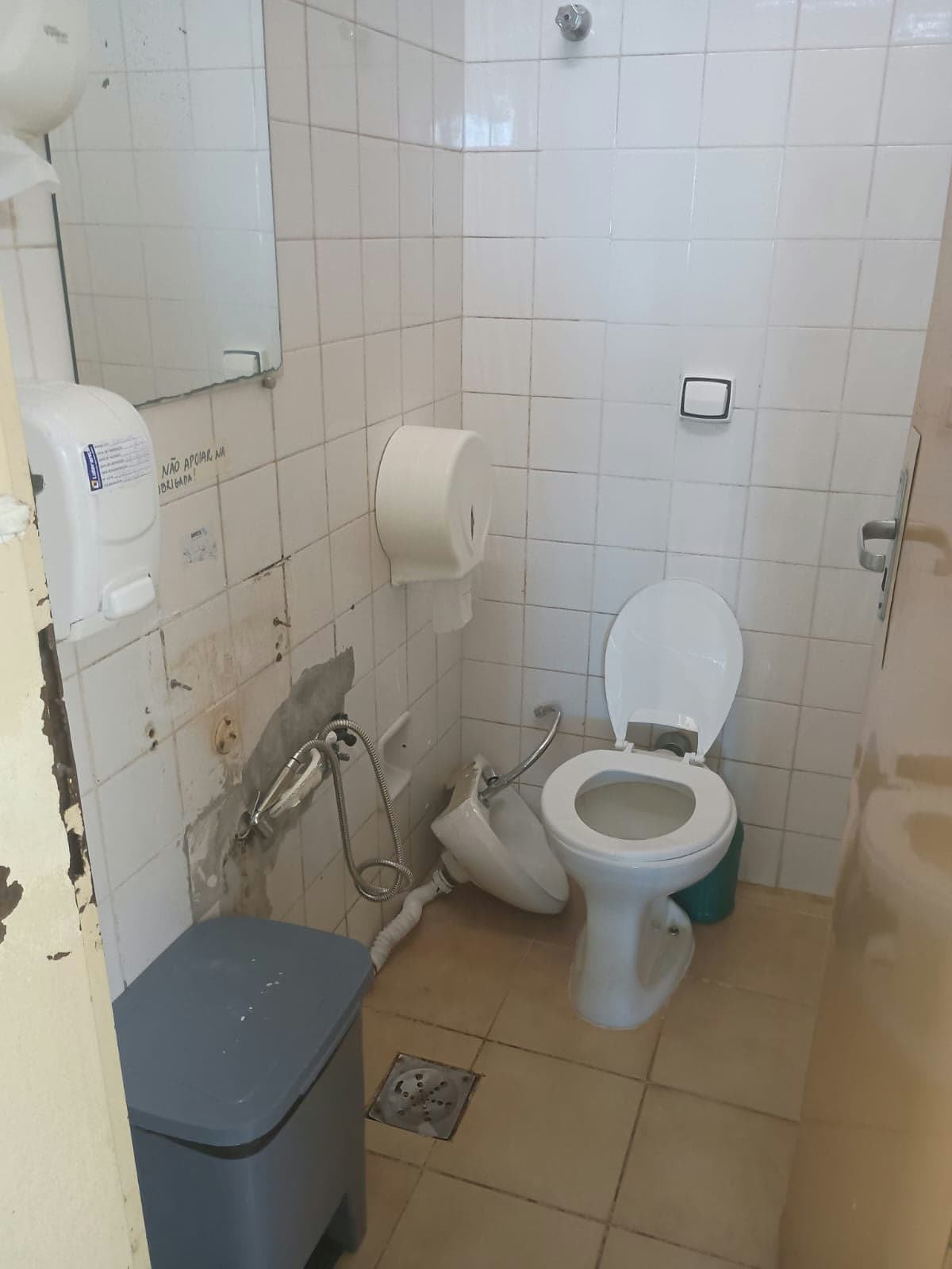 Banheiro com infiltração na parede e reboco caindo